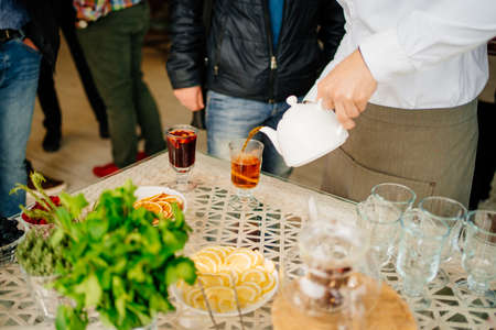 a man pours hot tea into a glass. warming drinkの写真素材