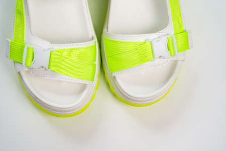 fashionable white with green sandals on the platform on a white background.の写真素材