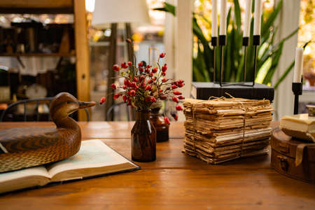 table decor in retro style. vase with rosehip berries and old booksの写真素材