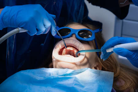 kid with oral dilator at dentists appointment. treatment of teeth