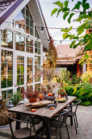 table in the backyard of the house decorated in autumn style.の写真素材