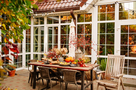 table in the backyard of the house decorated in autumn style.