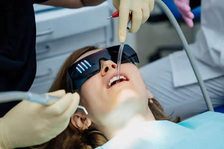 real. dentist treats patient with caries, drills tooth and installs filling