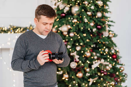 man with camera in red case against of Christmas decorations. photo schoolの写真素材