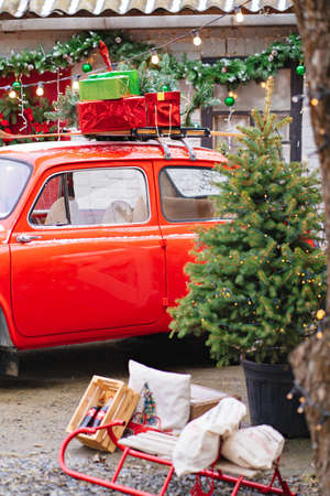 a red little car with a Christmas wreath by the porch of the house.のeditorial素材