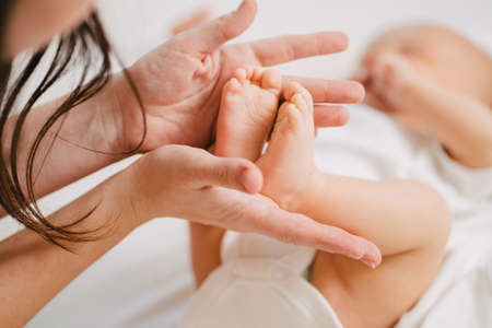 a gentle and loving mother keeps the babys legs.の写真素材