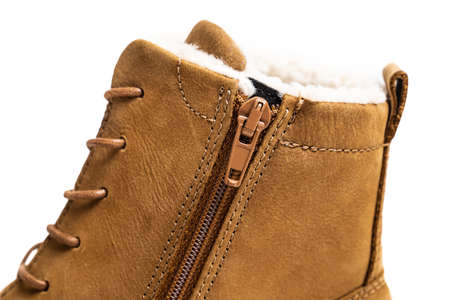 part of a brown leather winter boot with lacing on a white background