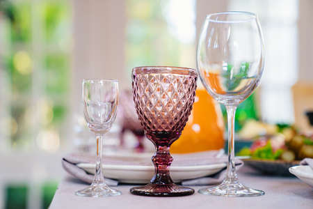 a shot, wine glass of white transparent and of colored glass on the table.の写真素材