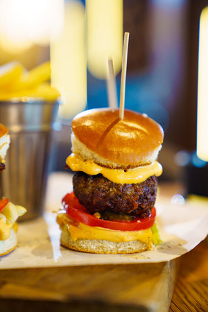 mini burger made of bun, cutlet, tomato, cheese and sauce.の写真素材