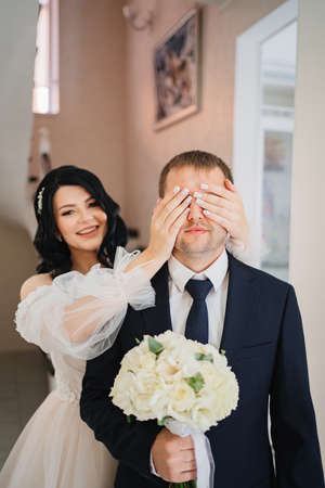 first meeting of newlyweds before ceremony.bride closed eyes to groom with handsの写真素材