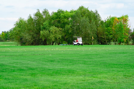landscape. electric car on golf course and sky with clouds. lawn grass.の写真素材