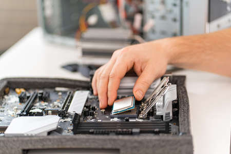 hand of repairman with a processor. professional services.の写真素材