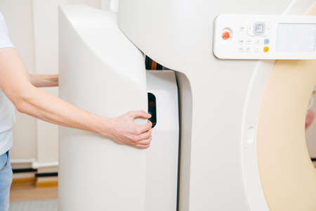 engineer removes cover of a computer tomograph.