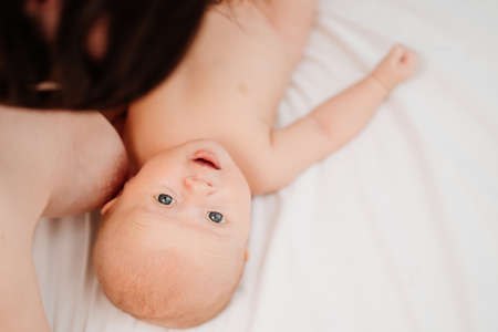 breastfeeding. view top. the baby lies next to the mothers breast after feeding