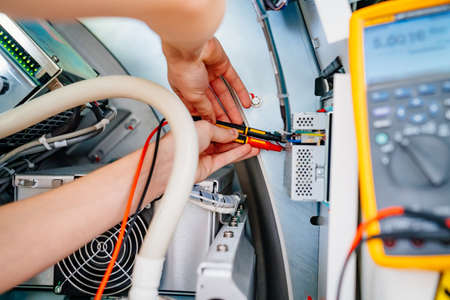 the engineer measures the voltage in the electrical appliance.の写真素材