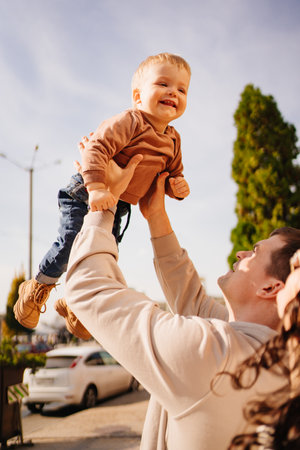 a happy family throws up a young son on a walk.の写真素材