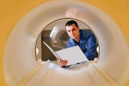 installer engineer of mri apparatus in scanner with instructions in handの写真素材