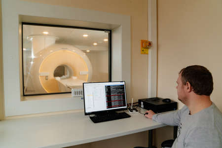 male engineer adjusts magnetic resonance imaging scannerのeditorial素材
