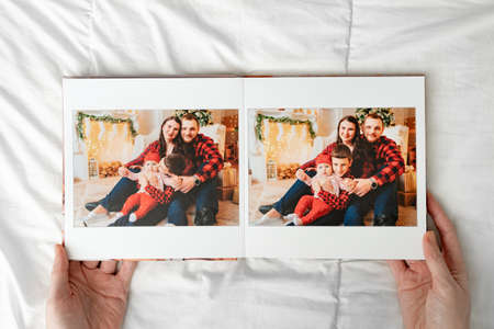 a hands with a book with photos of big family on a white background.