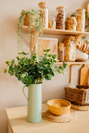 green metal retro jug with plant branches on the kitchen table.の写真素材