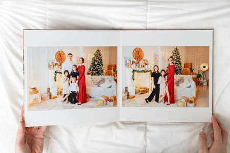 hands with opened photobook on a white background. family photo shoot