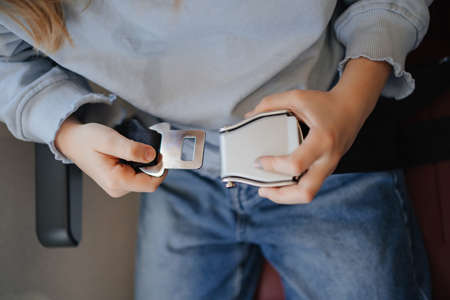hand of a little girl fastens her seat belt in a seat on board the plane.の写真素材