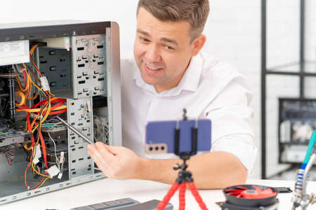 a man records a video lesson on computer repair or makes an online consultation.の写真素材