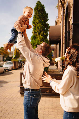 a happy family throws up a young son on a walk.の写真素材
