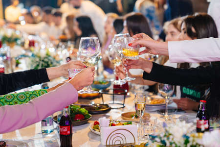 hands with glasses above the festive tableのeditorial素材
