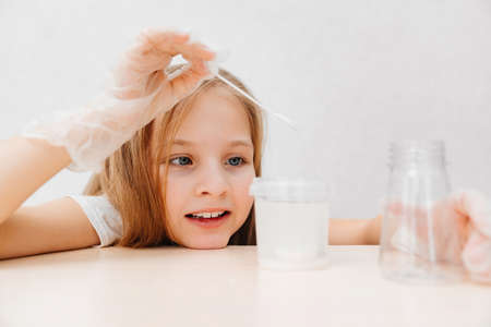 a cute little girl in protective gloves conduct an experiments at homeの写真素材