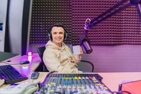 funny emotional radio host with headphones drinking tea on fun live streaming