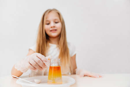 a cute little girl conduct an experiments at home. flask with colored liquidの写真素材