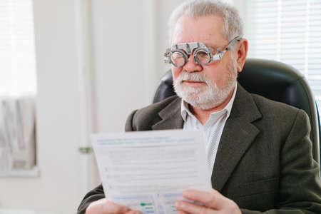 making a selection of lenses, diagnosing a elderly mans vision.
