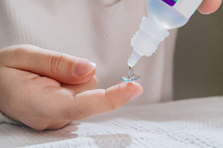 close-up. on contact lens on a childs finger drip eye drops.の写真素材