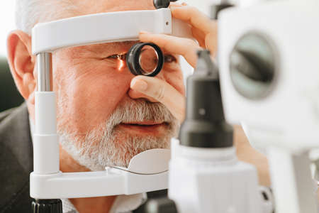 examination of elderly man with slit lamp. medical equipment