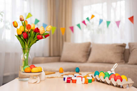 table with paints and decorated Easter eggs. table setting.