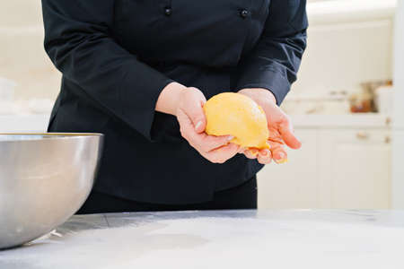 womens hands knead dough. homemade baking and cooking school.の写真素材