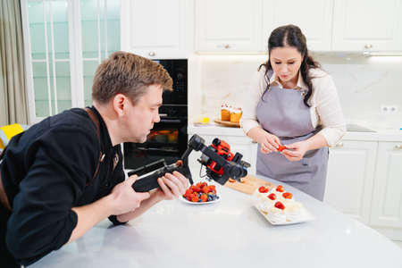A videographer takes a video for a cooks or pastry chef in kitchen.の写真素材