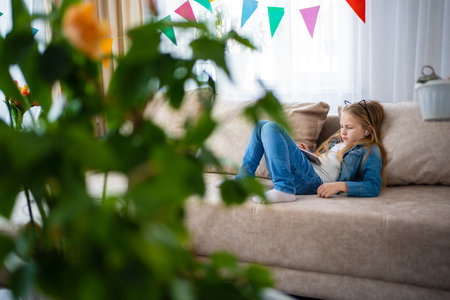A teenage girl listens to music on her phone with headphones.の写真素材