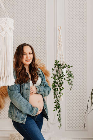 a attractive pregnant woman in a denim jacket with a naked tummyの写真素材