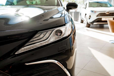 headlight on new black Toyota camry. purchase and sale of new cars in salon.