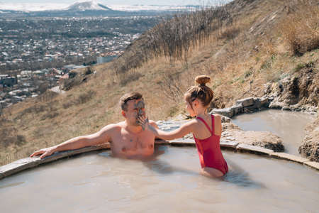 daughter applies healing clay to fathers face bathe in hydrogen thermal springの写真素材