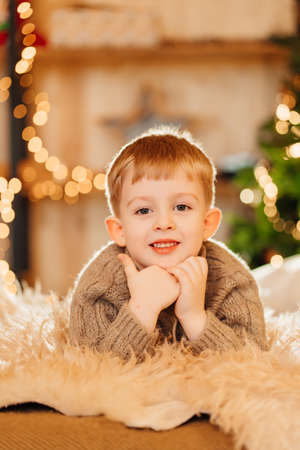 little boy in a sweater on a fluffy carpet. fashionable children clothing.の写真素材
