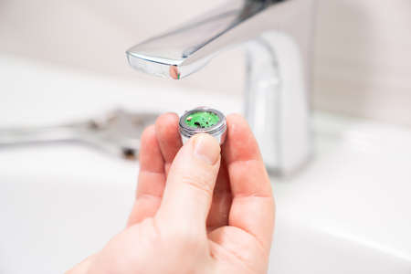 the repairman removes and cleans the Aerator from water stone and rust.の写真素材