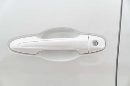the handle on the door on the white car. official dealerships and auto shops.