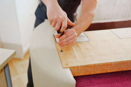 hands of a man assembles furniture. carpenter and handyman services