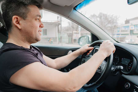 a cheery man drives a car on the highwayの写真素材