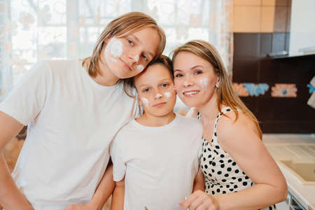 the mother and two sons of a teenager cook together and have fun in the kitchen.の写真素材
