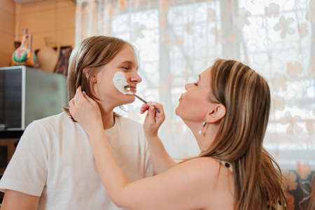 the mother and son of a teenager cook together and have fun in the kitchen.の写真素材