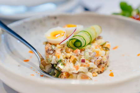 traditional Russian salad on a plate with cucumber and quail egg.の写真素材